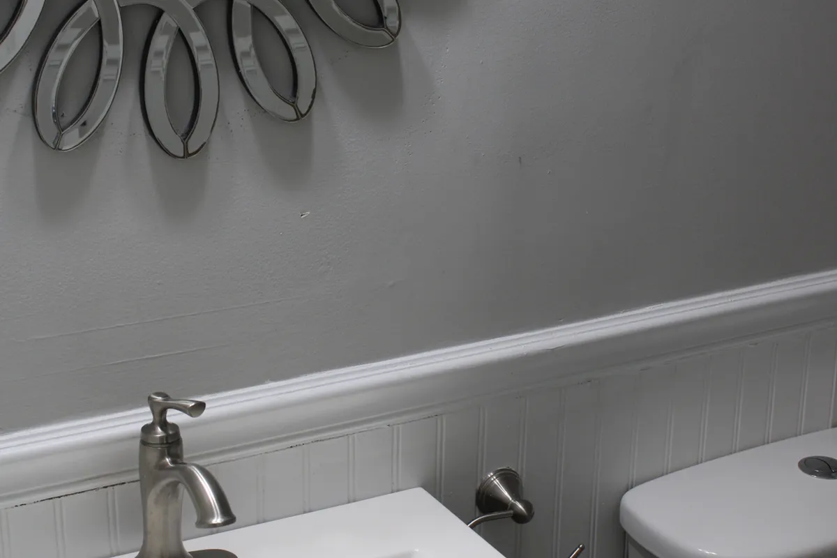 A modern bathroom with a sleek faucet, decorative mirror, and clean sink lines. The design exudes simplicity, cleanliness, and a sense of serene self-care—perfect for refreshing starts to the day.